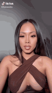 a woman in a very revealing top has a tiktok sticker on her face
