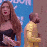 a woman is standing next to a man in a yellow suit .