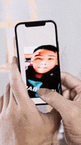 a person is taking a picture of a man on a cell phone that says a8 on it