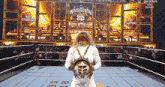 a woman in a wrestling ring holding a crown and a belt that says king queen of the ring
