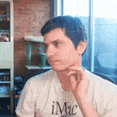 a man wearing a white t-shirt with the word imc on it