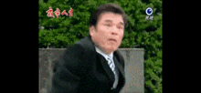 a man in a suit and tie is making a funny face .