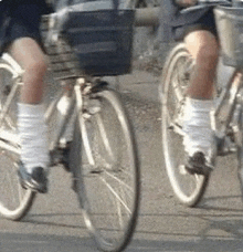 two girls are riding bicycles down a street .
