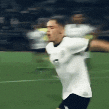 a blurry picture of a soccer player wearing a white shirt