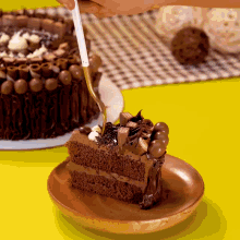 a person is cutting a slice of chocolate cake on a wooden plate