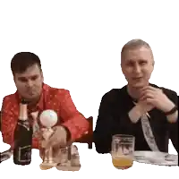 two men are sitting at a table with a bottle of champagne and a glass of beer
