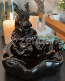 a black incense burner with a dragon on it sits on a table