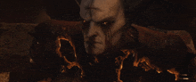 a demon with horns and red eyes looks at the camera