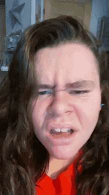 a woman in a red shirt makes a funny face