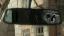 a skull is reflected in a rear view mirror of a car