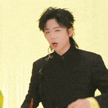 a young man wearing a black jacket and ear cuffs