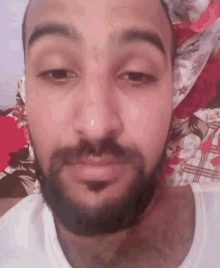 a close up of a man 's face with a beard and a white shirt .