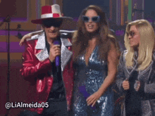 a woman in a blue dress stands next to a man in a red jacket with a microphone and the hashtag lialmeida05