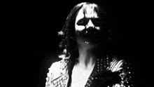 a black and white photo of a woman wearing a leather jacket with studs .