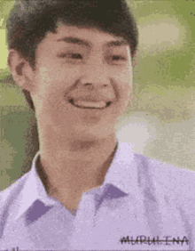 a young man wearing a white shirt and purple collar is smiling