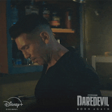 a man in a black shirt stands in front of a sign that says daredevil on it