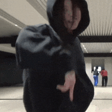a woman in a black hoodie is pointing her finger