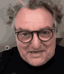 a man wearing glasses and a black shirt is making a funny face