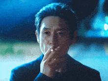 a man in a suit is smoking a cigarette in his hand