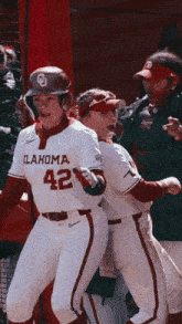 two oklahoma baseball players are celebrating a run