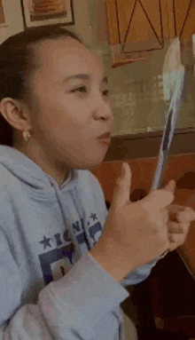 a girl wearing a blue hoodie that says icon on it