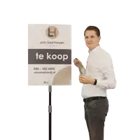 a man is holding a sign that says te verkocht