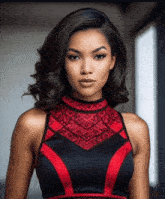 a woman wearing a black and red dress with a pattern on the neckline