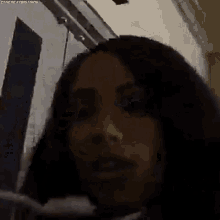 a close up of a woman 's face in a dark room with a blurred background .
