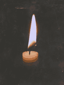 a candle is lit up in the dark and the flame is visible