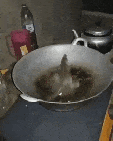 a bottle of long drink sits on a counter next to a pan of food