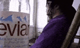 a bottle of evian water sits next to a man in a chair
