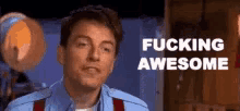 a man in a blue shirt and red suspenders says fucking awesome
