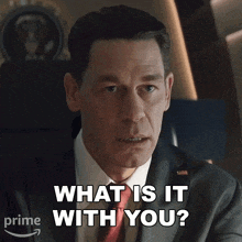 a man in a suit is asking what is it with you