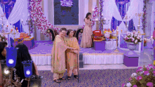 a woman in a pink dress stands next to a woman in a yellow dress
