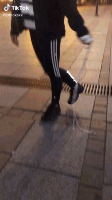a person is walking down a sidewalk with a tik tok watermark
