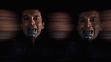 a blurry picture of a man singing into a microphone with the letter r on it