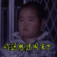 a little girl is making a funny face in front of a fence .