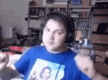 a man wearing headphones and a blue shirt with a picture of a man on it .