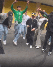a group of people are dancing in front of a garage door