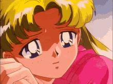 a close up of a girl 's face with a pink shirt on and a sad look on her face .