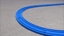 a toy train is going down a track on a carpet .
