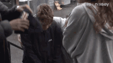 a person wearing a fila sweatshirt is being held by a woman