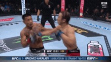 two men are fighting in a boxing ring and the ufc fight is live