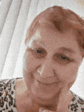 a woman with red hair is smiling with her hand on her face