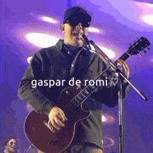 a man singing into a microphone while holding a guitar with the words gaspar de romi below him
