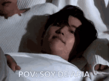 a man is laying in a bed with the words pov soy de aria written on the bottom .