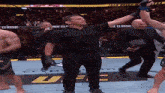 a referee holds up a fighter 's arm in front of a sign that says ufc