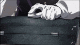 a man wearing white gloves is holding a black briefcase