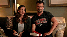 a man wearing a georgia shirt sits next to a woman