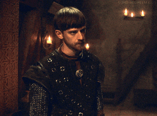 a man with a beard in a dark room with candles and the words lord-aldhelm gifs